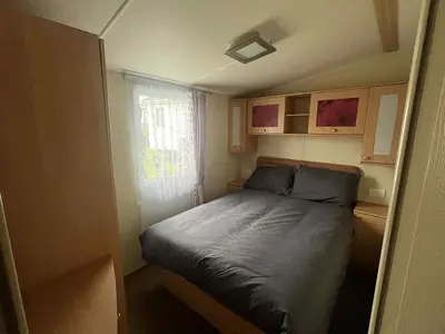 a small bed in a small room with a window at Pet Friendly Static in Carnbrea Station