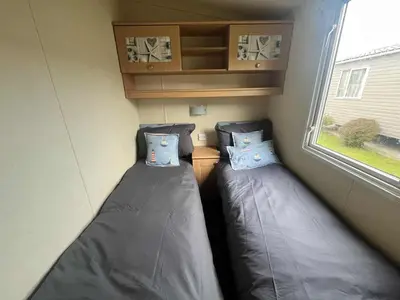 two beds in a small room with a window at Pet Friendly Static in Carnbrea Station