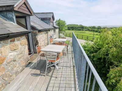 a wooden deck with a table and chairs on it at The Cottage in St Ives