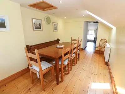 a dining room with a wooden table and chairs at The Cottage in St Ives
