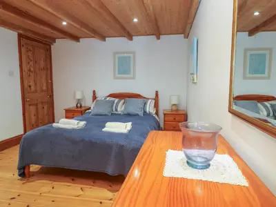 a bedroom with a bed and a glass bowl on a table at The Cottage in St Ives