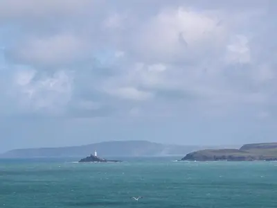 a lighthouse on an island in the middle of the ocean at The Cottage in St Ives