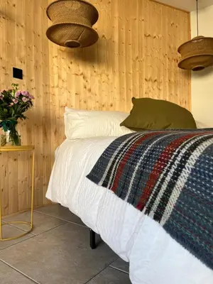 a bedroom with a bed with a wooden wall at Treth Newquay in Newquay