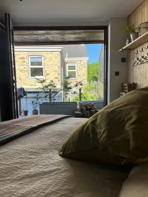 a bed in a room with a large window at Treth Newquay in Newquay