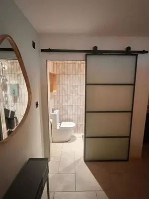 a bathroom with a door leading to a toilet at Treth Newquay in Newquay
