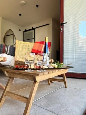 a wooden table with wine bottles and wine glasses on it at Treth Newquay in Newquay