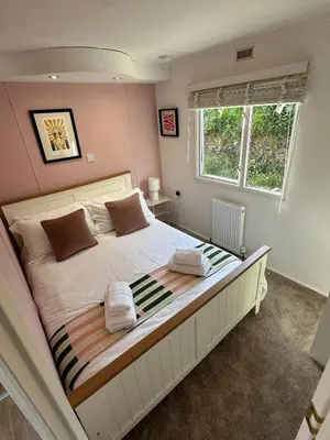 a bedroom with a large bed with two towels on it at Static Caravan Near Perranporth in Perranporth