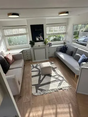 a living room with two couches and a rug at Static Caravan Near Perranporth in Perranporth