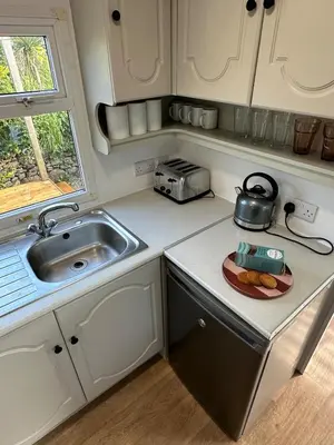 a kitchen with a sink and a plate of food at Static Caravan Near Perranporth in Perranporth