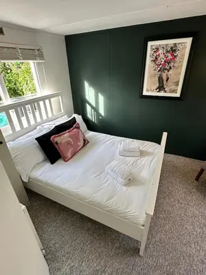 a bed in a bedroom with a green wall at Static Caravan Near Perranporth in Perranporth