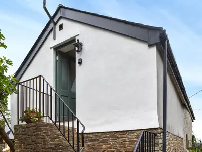 a white house with a green door and stairs at Roseland Roost - Uk49839 in Truro