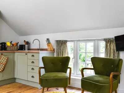 two green chairs in a kitchen with a window at Roseland Roost - Uk49839 in Truro