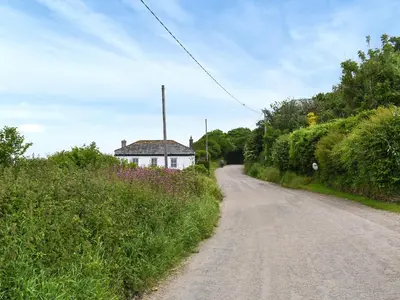 a dirt road in front of a white house at Roseland Roost - Uk49839 in Truro