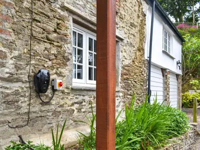 a stone house with a phone on the side of it at Roseland Roost - Uk49839 in Truro