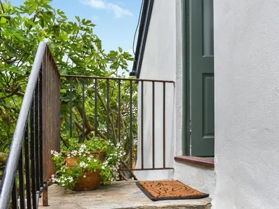 an open door to a balcony with plants on it at Roseland Roost - Uk49839 in Truro