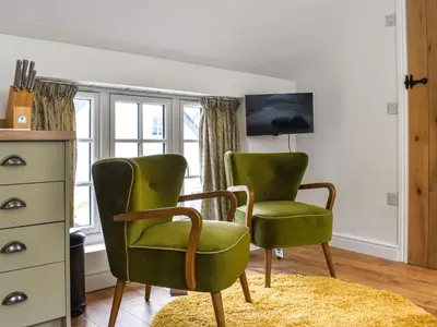 two green chairs in a room with a window at Roseland Roost - Uk49839 in Truro