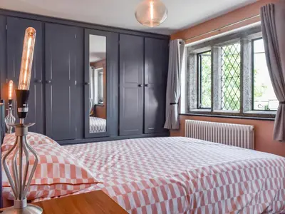 a bedroom with a bed and a mirror at Rivendell Cottage in Liskeard