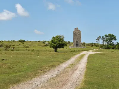 a dirt road leading to an old building on a field at Rivendell Cottage in Liskeard