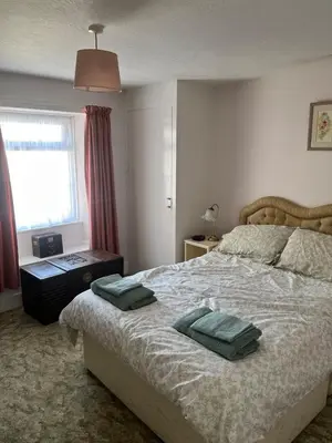 a bedroom with a bed with two green pillows on it at Maureen's Cottage in Padstow