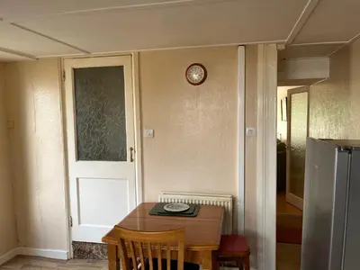 a room with a table and a clock on the wall at Maureen's Cottage in Padstow