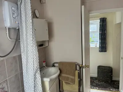a small bathroom with a toilet and a sink at Maureen's Cottage in Padstow