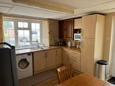 a kitchen with a sink and a washing machine at Maureen's Cottage in Padstow