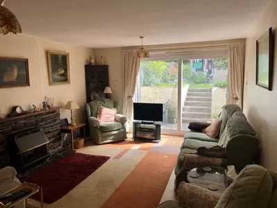 a living room with a couch and a television at Maureen's Cottage in Padstow