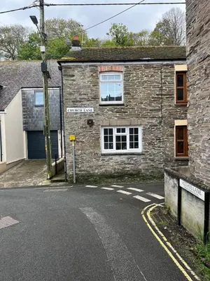 an old stone building with a street in front of it at Maureen's Cottage in Padstow