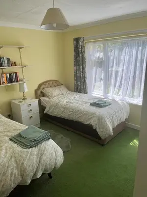 a bedroom with two beds and a window at Maureen's Cottage in Padstow