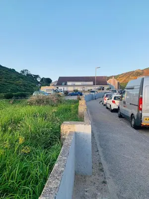 a parking lot with cars parked on the side of a road at Lovely two bed flat with a sea view next to beach in Porthtowan