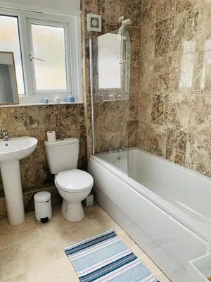 a bathroom with a toilet and a tub and a sink at Lovely two bed flat with a sea view next to beach in Porthtowan