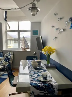 a living room with a table and a couch at 'Shorebird' central apartment, sea views & parking in Falmouth