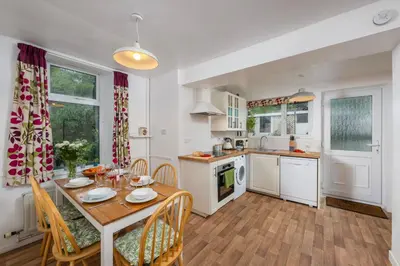 a kitchen and dining room with a table and chairs at Penstraze cottage near Gylly Beach in Falmouth