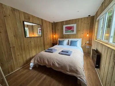 a bedroom with a bed with two towels on it at Cornish wooden cabin & wood fired hot tub in Gwennap