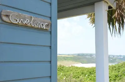 a sign on the side of a blue house at C14 Gwelmore, Riviere Towans in Hayle