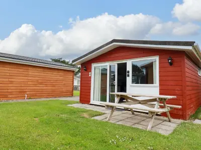 a red shed with a picnic table in front of it at H2 Atlantic Bay Holiday Park in Padstow