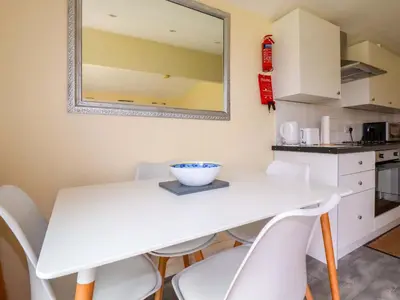 a kitchen and dining room with a white table and chairs at H2 Atlantic Bay Holiday Park in Padstow