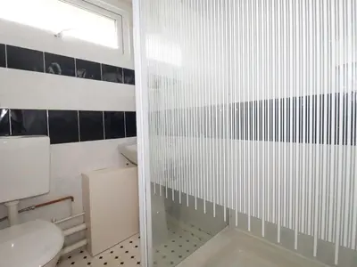 a bathroom with a toilet and a glass shower at H2 Atlantic Bay Holiday Park in Padstow