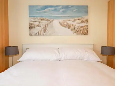 a bedroom with a white bed and a painting on the wall at 161 Atlantic Bay Holiday Park in Padstow