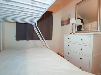 a bedroom with a white bed and a white dresser at 161 Atlantic Bay Holiday Park in Padstow