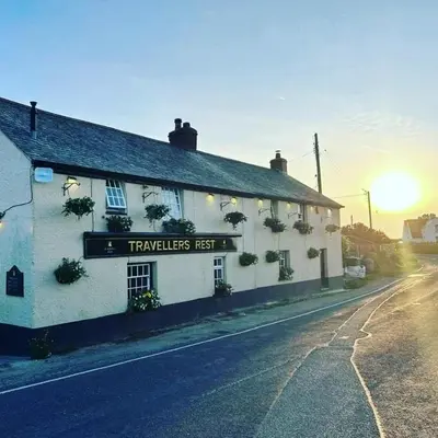 a inn with a sign on the side of a building at Travellers Rest Glamping Pods & Shepherds Hut in Newquay