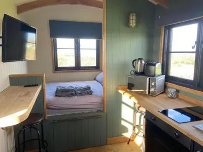 a small bedroom with a bed in a tiny house at Travellers Rest Glamping Pods & Shepherds Hut in Newquay