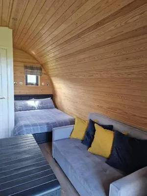 a living room with two beds and a couch at Travellers Rest Glamping Pods & Shepherds Hut in Newquay