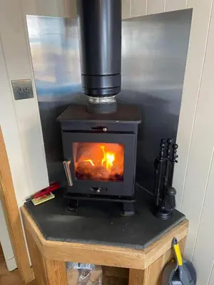 a wood stove sitting on a table in a room at Travellers Rest Glamping Pods & Shepherds Hut in Newquay