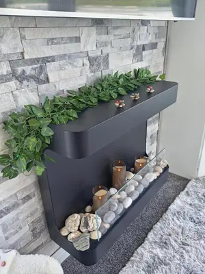 a black shelf on a wall with rocks and plants at Newquay Bay Resort - Poppy's Lodge Retreat in Newquay