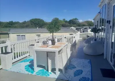 a balcony with a table and a tree on it at Newquay Bay Resort - Poppy's Lodge Retreat in Newquay