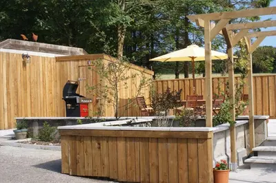a backyard with a fountain and an umbrella at Lower Mulberry Cottage in Bodmin