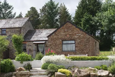 a stone house with a garden in front of it at Lower Mulberry Cottage in Bodmin