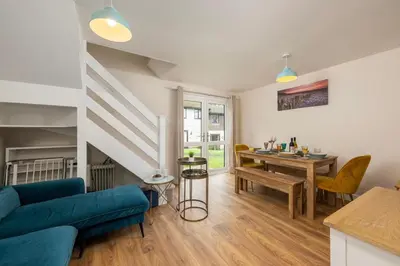 a living room with a blue couch and a table at Perfect place for family time in Hayle