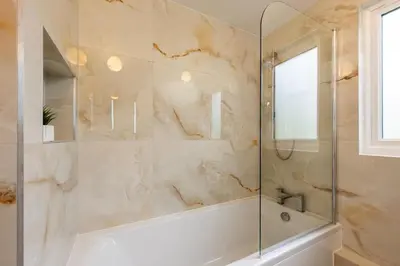 a bathroom with a tub and a glass shower at Perfect place for family time in Hayle